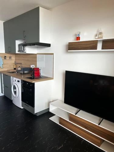 une petite cuisine avec une cuisinière et un micro-ondes dans l'établissement Studio climatisé belle vue mer, à Ajaccio