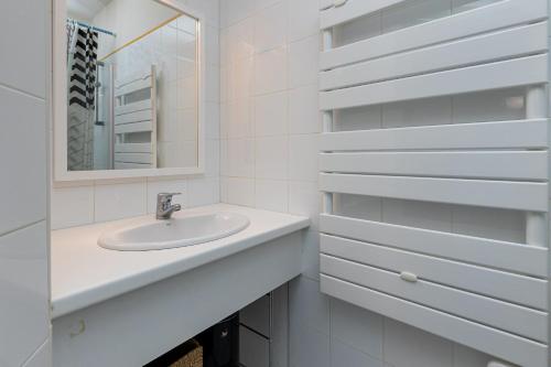 une salle de bain blanche avec un lavabo et un miroir dans l'établissement Appartement Fred, à Moliets-et-Maa