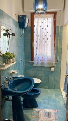 a bathroom with a blue sink and a window at Home Garden in Roseto degli Abruzzi