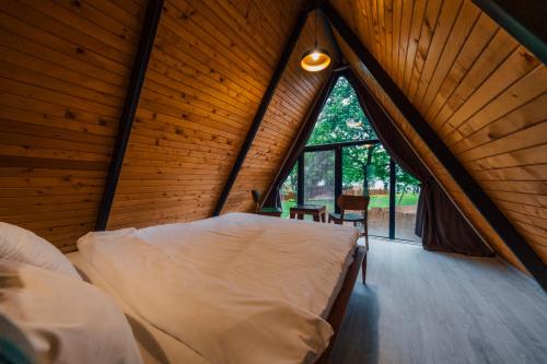 a bedroom with a large window in a wooden cabin at Kurtköy Park Bungalov Evleri in Sakarya