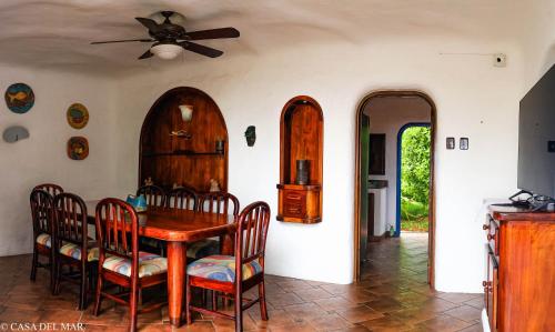 a dining room with a wooden table and chairs at Casa del Mar in Puerto Ayora