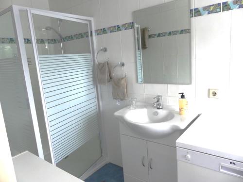 a white bathroom with a sink and a shower at Ferienwohnung Schweizer in Coswig