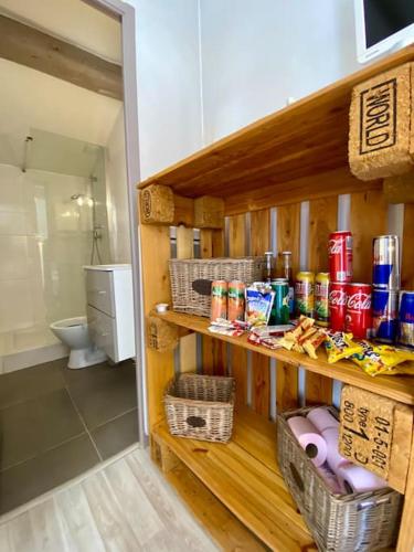 une salle de bain avec toilettes et une étagère avec des canettes de soda dans l'établissement Le Grenier en Hyper Centre, à Nîmes
