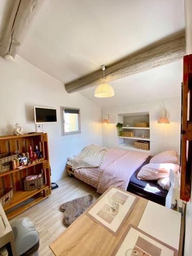 une chambre avec deux lits et une table dans l'établissement Le Grenier en Hyper Centre, à Nîmes