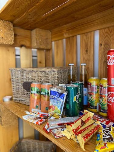 une table en bois avec des canettes de soda et des collations dessus dans l'établissement Le Grenier en Hyper Centre, à Nîmes