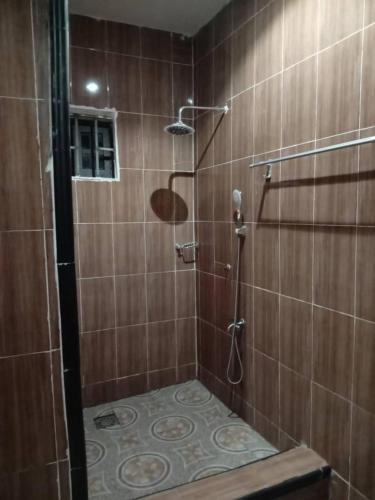 a bathroom with a shower with wooden tiles at Koohan Hotel in Bibiani