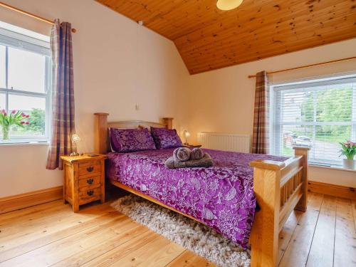um quarto com uma cama roxa num quarto com janelas em 1 Bed in North York Moors 56590 em Castleton