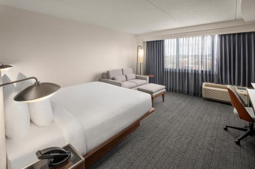um quarto de hotel com uma cama e uma cadeira em Courtyard New Haven at Yale em New Haven