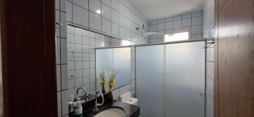 a bathroom with a sink and a mirror at Apartamento Vista para Mar in Guriri