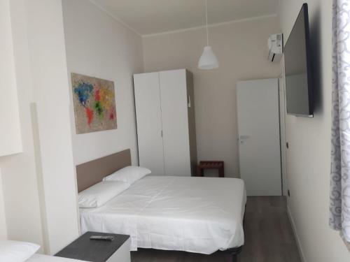 a small white bedroom with a bed and a table at Appartamento "A2 passi" in Siderno Marina