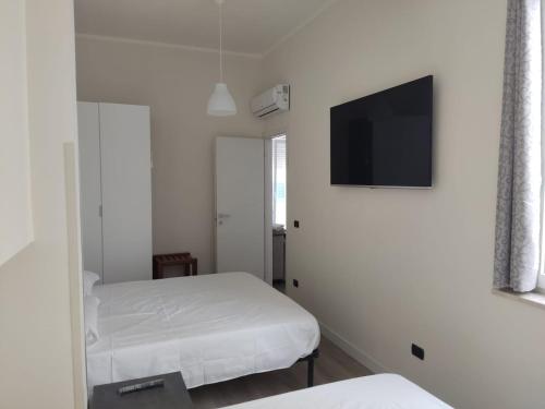 una camera con 2 letti e una TV a schermo piatto di Appartamento "A2 passi" a Siderno Marina