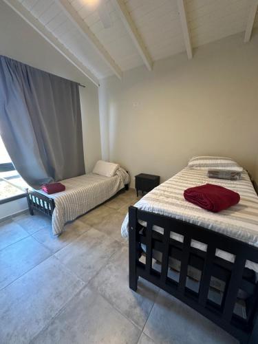 zwei Betten in einem Zimmer mit Fenster in der Unterkunft villa marina in Villa General Belgrano