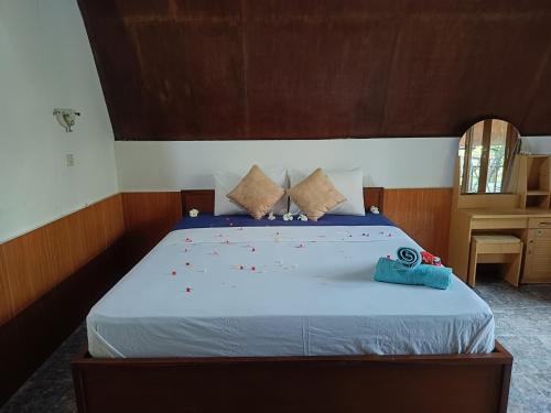 a bedroom with a bed with red confetti on it at Noby Gili Cottages in Gili Meno