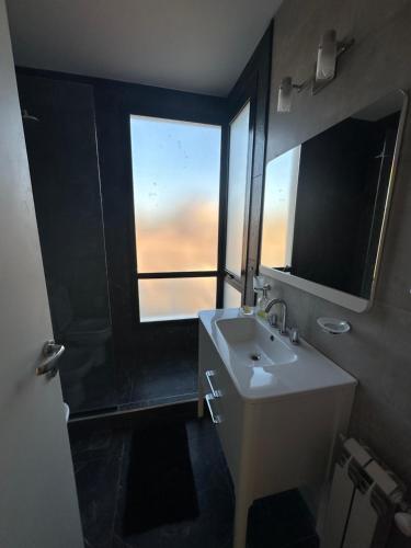 ein Badezimmer mit Waschbecken und großem Fenster in der Unterkunft villa marina in Villa General Belgrano