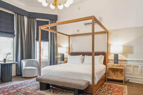 1 dormitorio con cama con dosel y silla en The White House Napa Valley en Napa