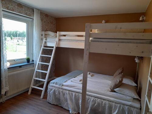 1 Schlafzimmer mit 2 Etagenbetten und einem Fenster in der Unterkunft Kristinebergs Bed & Breakfast in Mora
