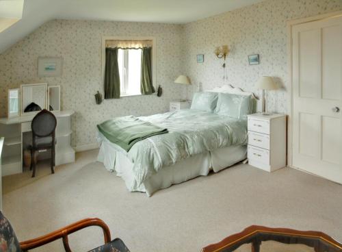um quarto com uma cama, uma secretária e uma cadeira em 5 bedrooms house at Co Kerry 500 m away from the beach with sea view enclosed garden and wifi em Kells