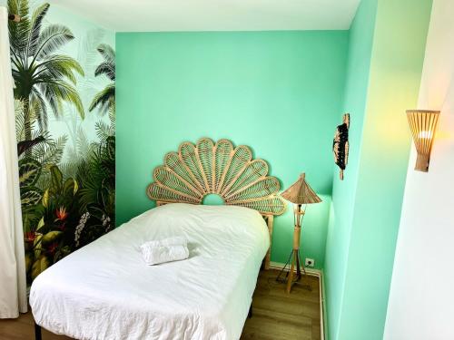 - une chambre avec un lit et un ventilateur dans l'établissement Evasion dépaysante en bord de Garonne, à Toulouse