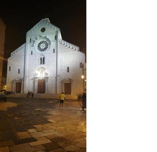 a large white church with a clock tower at night at AL VECCHIO ARCO a Bari vecchia in Bari