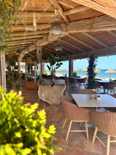 un patio con mesa, sillas y el océano en Village Vacances La Vallicella en Poggio-Mezzana
