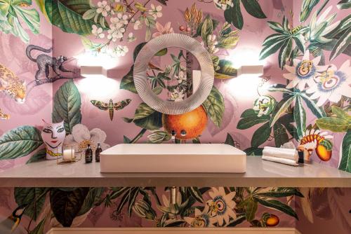 a bathroom with a sink with a flower wallpaper at La Villa in Franschhoek