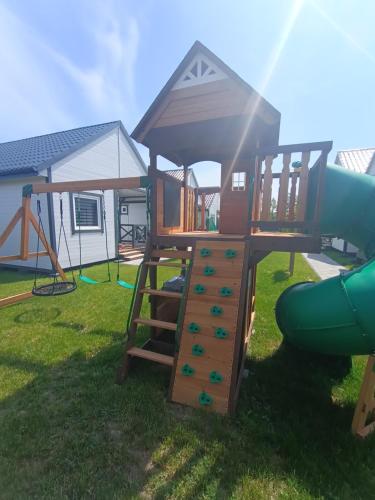 een speeltuin met een glijbaan en een speelstructuur bij Bałtyk i Las in Rusinowo