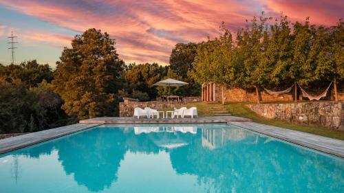 una piscina con 2 sillas y una mesa en Portugal Active River Lodge - Heated Pool near the beach, en Vila Praia de Âncora