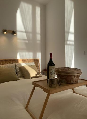 - une bouteille de vin assise sur une table sur un lit dans l'établissement Lady of the Lake, à Huelgoat