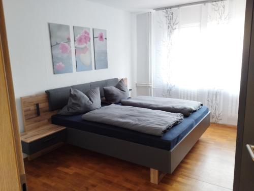 um quarto com uma cama com uma estrutura de cama azul em Ferienwohnung Hohenberg em Dingelstädt