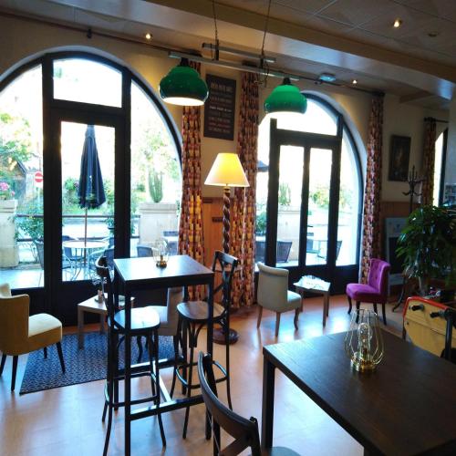 a restaurant with tables and chairs and large windows at Hôtel du Pont et Restaurant à Groléjac in Groléjac