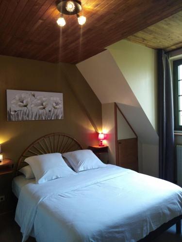 a bedroom with a large white bed in a room at Hôtel du Pont et Restaurant à Groléjac in Groléjac