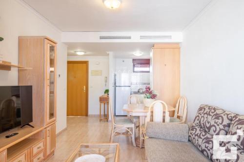 ein Wohnzimmer mit einem Sofa und einem Tisch in der Unterkunft Apartamento Nautilus 39B - Grupo Turis in Calpe