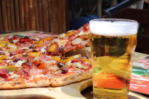 a slice of pizza and a glass of beer at B&B 7 Vizi in Colà di Lazise