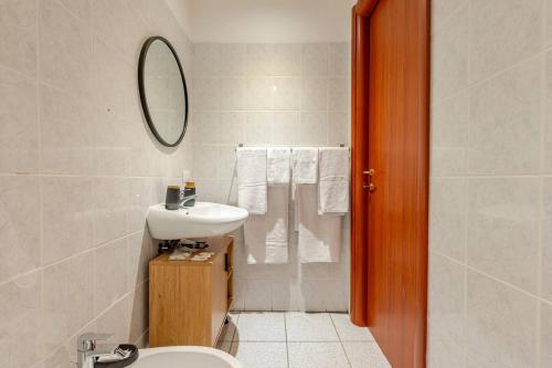 a bathroom with a sink and a toilet and a mirror at La Casetta-10 min Aeroporto e spiaggia in Fiumicino