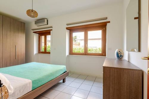 a bedroom with a bed and two windows at La Casetta-10 min Aeroporto e spiaggia in Fiumicino