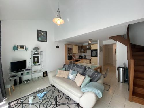 un salon avec un canapé et une cuisine dans l'établissement Appartement entre mer et pins - PARKING, à Les Sables-dʼOlonne