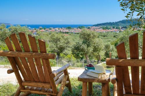 zwei Holzstühle neben einem Tisch mit Büchern in der Unterkunft Helicon Luxury Villas in Limenas