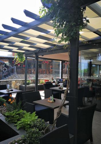 a restaurant with tables and chairs and a largeolean at Bracera Inn in Malinska