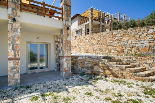 a stone wall with a door in front of a building at Helicon Luxury Villas in Limenas