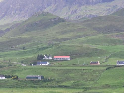 a group of houses on a green hillside at Skye Stays in Staffin