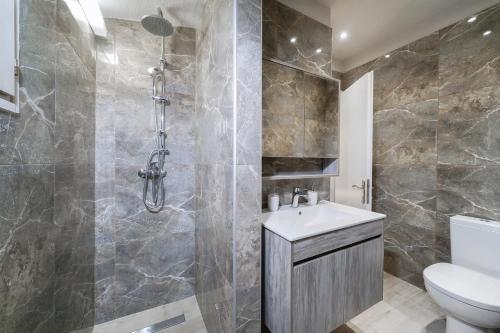 a bathroom with a shower and a toilet and a sink at Helicon Luxury Villas in Limenas