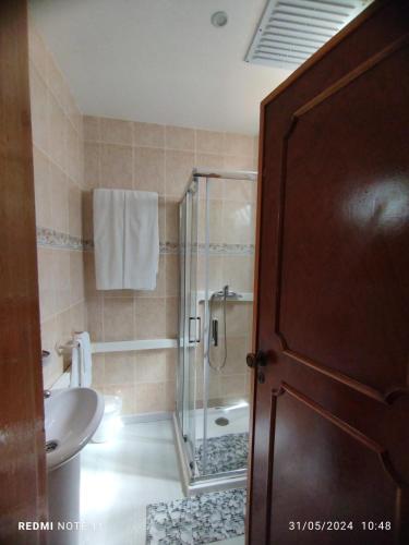 e bagno con doccia, servizi igienici e lavandino. di Apartamentos das Avós-Flor a Nazaré