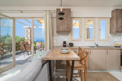 a kitchen and living room with a table and a couch at Helicon Luxury Villas in Limenas