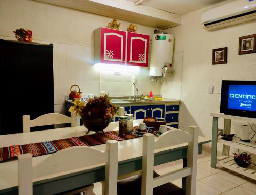 una cucina con tavolo, sedie e TV di Studios La Bella Vida en Escobar a Belén de Escobar