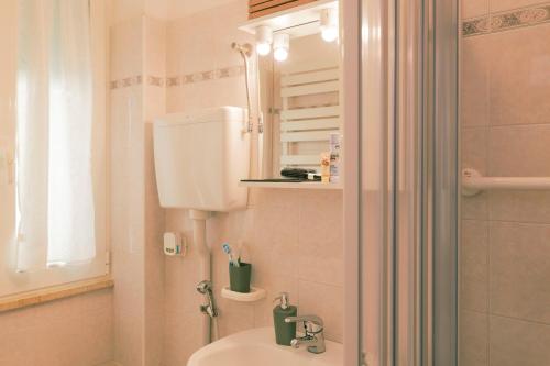 a bathroom with a sink and a toilet and a mirror at La Perla del Sole - Sunset on the beach in Lido di Pomposa