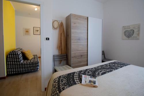 a small bedroom with a bed and a chair at La Perla del Sole - Sunset on the beach in Lido di Pomposa
