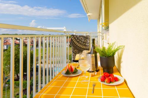 a table with fruit and wine glasses on a balcony at La Perla del Sole - Sunset on the beach in Lido di Pomposa