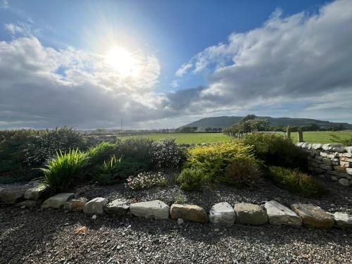 a garden with a stone wall and some plants at Mia's Self Catering Holiday Cottage Donegal in Claggan