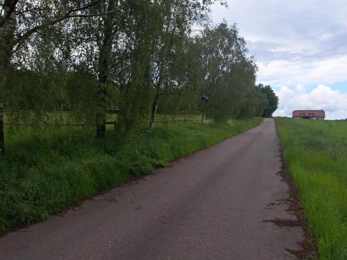a road in a field with a house in the distance at Haus Eufalia in Blankenheim