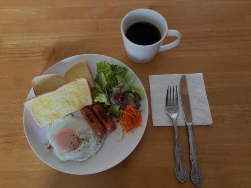Hostel Mt. Fuji - FUKUYA في فوجيوشيدا: طبق من طعام الإفطار مع كوب من القهوة